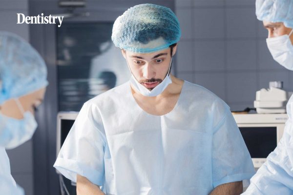 A dentist with his mask down looking like he has no dental confidence